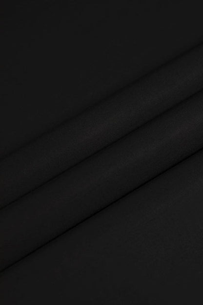 Istanbul Noir fabric by SGF — close-up flat lay texture of deep black premium unstitched fabric with subtle shine, men’s luxury fabric Pakistan.