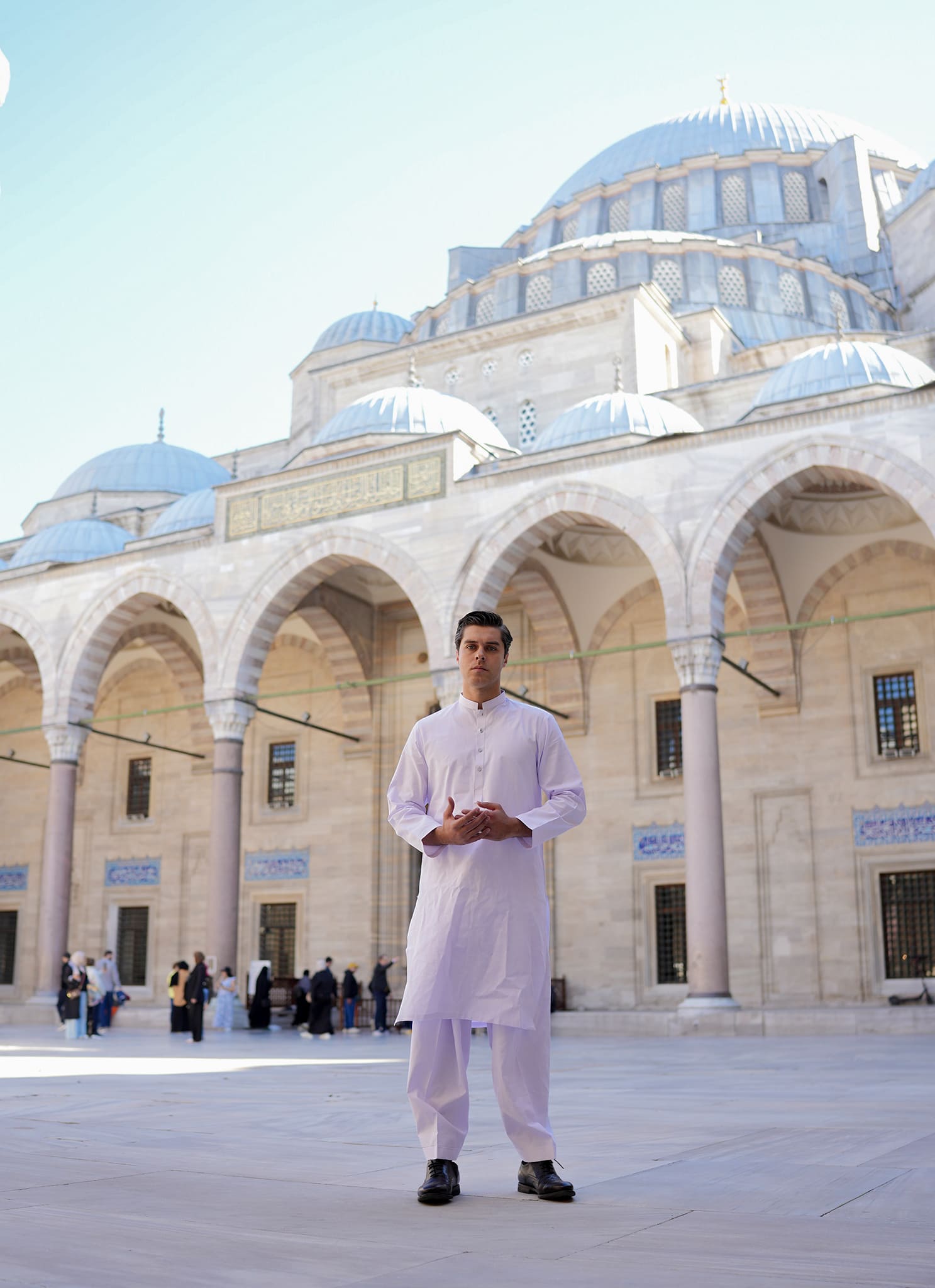 White Sultan premium fabric by Sheikh Gulzar Fabrics — men in radiant white shalwar kameez styled in mosque courtyard, luxury unstitched fabric Pakistan.